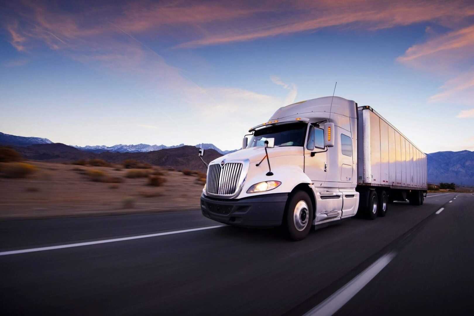 A white truck is driving down the road.