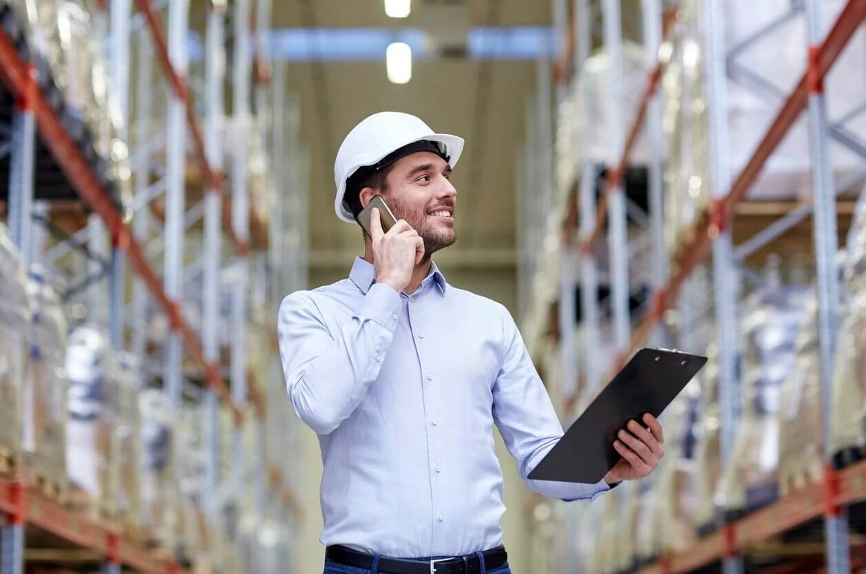 A man in a hard hat talking on the phone.