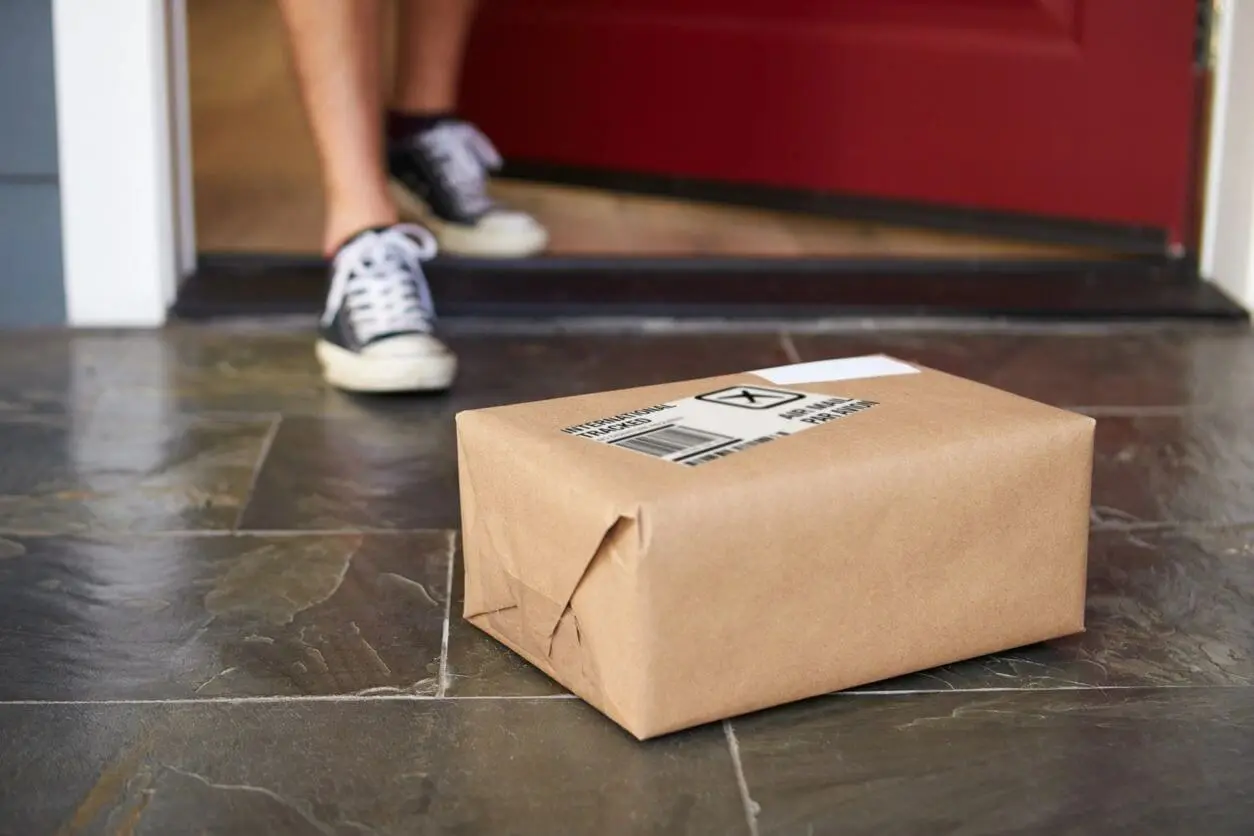 A person sitting on the ground with a box